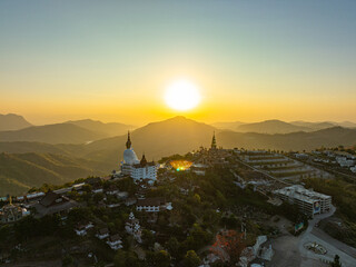 Obraz premium Aerial view beautiful sunrise above Big White Five buddha Statues in Wat Phra That Pha Son Kaew temple at Phetchabun Thailand. beautiful and famous landmark in Thailand. sea of mist background.
