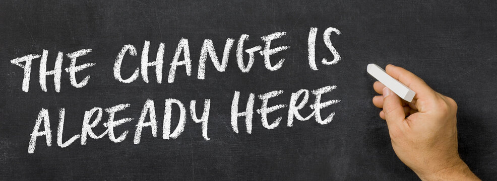 Text written on a blackboard - The Change Is Already Here