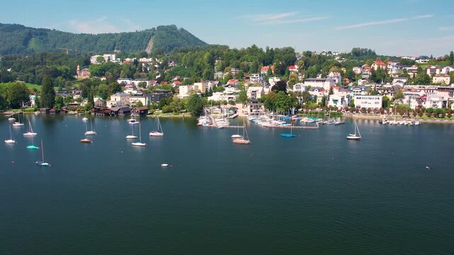 Aerial of beautiful resort town Gmunden on mountain Lake Traunsee, Salzkammergut. Serene lake, high Alp mountain, boats and picturesque buildings along the shoreline. Austria tourism and scenic places