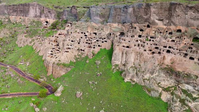 drone wide angle aerial view of Vardzia cave monastery complex and Mtkvari River canyon, Georgia