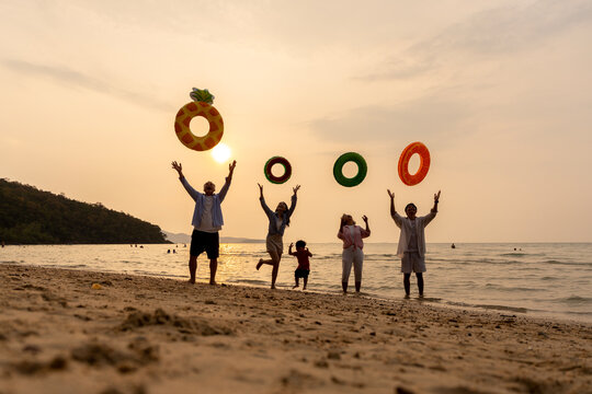 Golden Happiness: Joyful Multi-generational Family Jumping on the Beach at Sunset