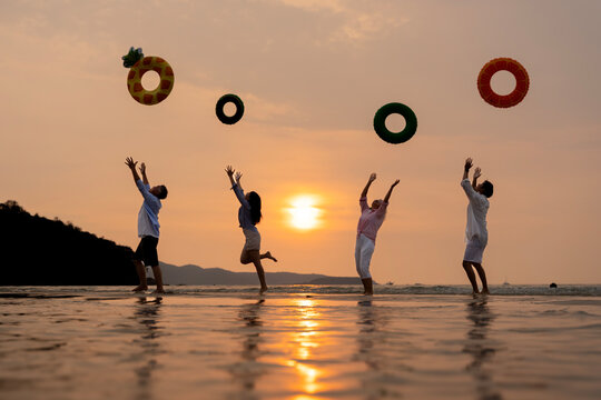 Golden Happiness: Joyful Multi-generational Family Jumping on the Beach at Sunset