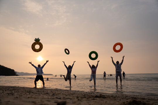 Golden Happiness: Joyful Multi-generational Family Jumping on the Beach at Sunset
