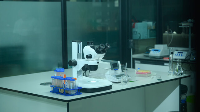Stereo Microscope on Laboratory Workbench with Test Tubes, Pipette Tips, and Scientific Equipment