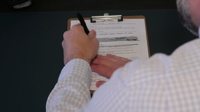 Concept - Government military documents marked Top Secret or Classified featuring lines of text blacked out with heavy ink marker edited redactions