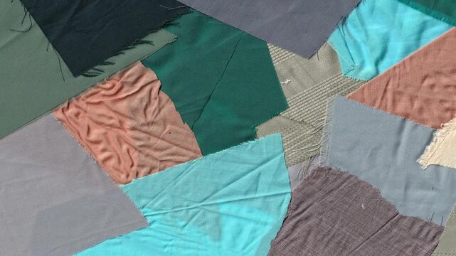 Animated patchwork fabric texture background featuring colorful layered scraps of textile material with various patterns and woven surfaces for creative fashion video projects.
