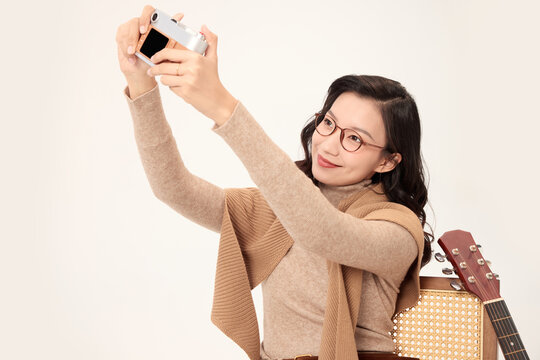 Smiling woman taking selfie with compact camera