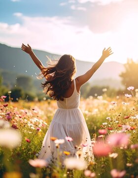 Woman in white dress running through colorful flower field, arms outstretched, enjoying the sunset