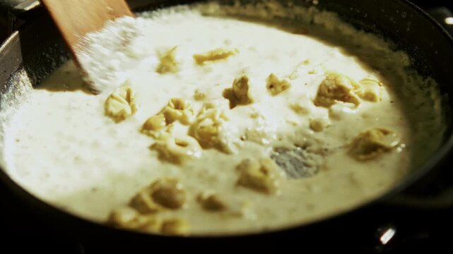 Stirring Italian Ravioli In Creamy Sauce. Pasta Dinner In Frying Pan.   Hot Meal Culinary Food Preparation