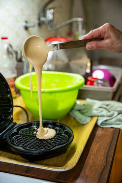 The hostess prepares the cakes heart waffle,old-fashioned way, using traditional European cuisine and utensils.