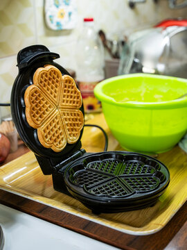 The hostess prepares the cakes heart waffle,old-fashioned way, using traditional European cuisine and utensils.