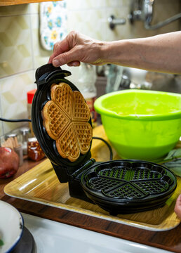The hostess prepares the cakes heart waffle,old-fashioned way, using traditional European cuisine and utensils.