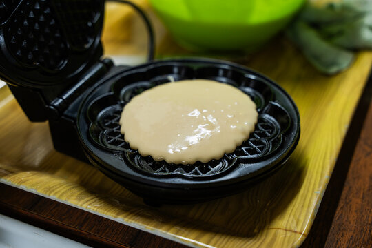 The hostess prepares the cakes heart waffle,old-fashioned way, using traditional European cuisine and utensils.