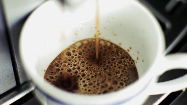 Fresh Espresso Pouring Into White Ceramic Cup. Making Morning Caffeine Beverage. Breakfast Energy Refreshment