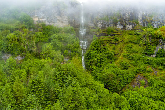 Devils Chimney Waterfall dropping through misty cliffs near Glencar Lough, Ireland. Dramatic cascade in the lush northwest landscape of County Sligo and Leitrim.
