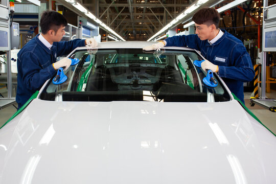 Asian workers installing car windows