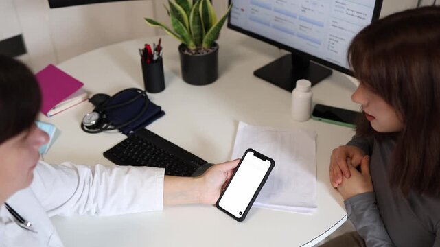 Doctor checks treatment recommendations with artificial intelligence before confirming medical prescription for young female patient during consultation in modern clinic