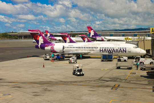 Airport ground crew member operating a service cart on the ramp with a Hawaiian Airlines Boeing  parked at terminal gate A19, Daniel K. Inouye International Airport, Honolulu,