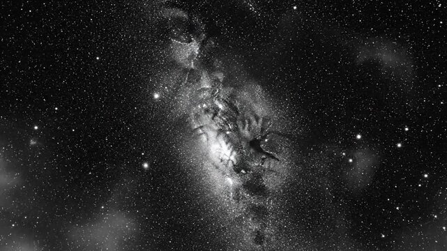 Black and white view of a nebula in space with a bright light and numerous stars visible in the background