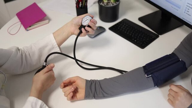 Close up of routine blood pressure measurement during standard medical examination in modern clinic with doctor checking patient cardiovascular health during preventive appointment
