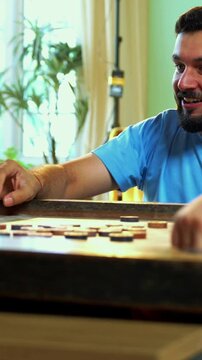 Family playing carrom board game together at home, enjoying bonding time with young children