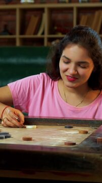 Family playing carrom board game together at home, enjoying bonding time with young children