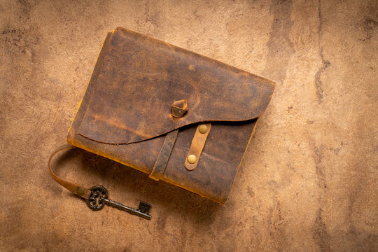 retro leather bound journal with decked edge handmade paper pages and a key, journaling concept