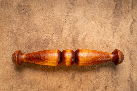 Wooden Tai Chi ruler, a  traditional Chinese exercise tool, on textured bark paper