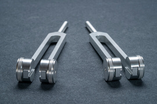 Weighted metal tuning forks used for tuning musical instruments, sound therapy, chakra healing or relaxation.