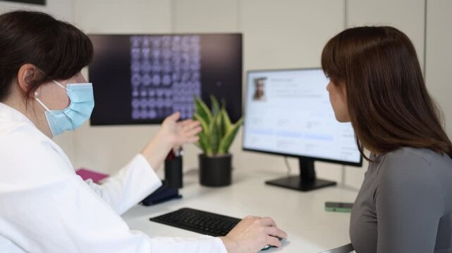 Doctor discussing brain scan results with young woman during medical consultation physician explaining diagnosis and treatment options in modern clinic office