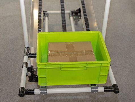 Cardboard Box Package in Green Plastic Crate Storage Shelf