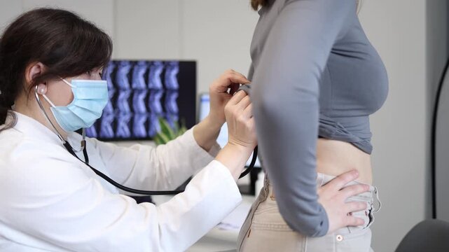 Doctor listening to patient breathing with stethoscope during medical examination young woman standing in clinic office for respiratory and chest health checkup