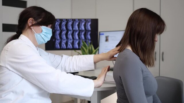 Doctor checking posture and spine alignment during medical examination young woman visiting clinic because of back pain muscle tension and sedentary lifestyle problems