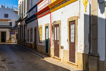 Fototapeta premium Whitewashed street facade with colorful trim and doors