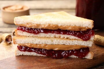 Obraz premium Tasty sandwiches with peanut butter, jam and nuts on table, closeup