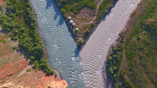 Zenith drone view of river confluence with yurt camp on peninsula between Chong and Kichi Naryn, Kyrgyzstan