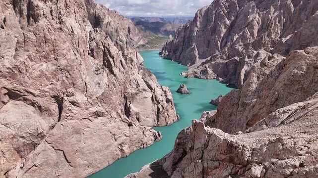 Aerial view of Kol-Suu Lake canyon with isolated rock formations in turquoise glacial water, Kyrgyzstan