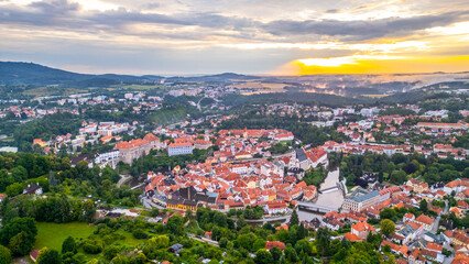 Fototapeta premium At sunrise, Cesky Krumlov awakens as soft light illuminates its colorful rooftops and the Vltava River.