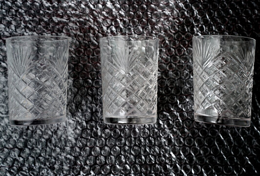 Glass tumbler set on bubble pack plastic wrapping background