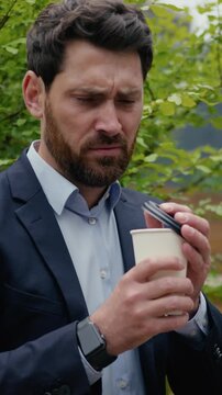 Dissatisfied businessman Caucasian man drinking coffee tea outdoors bad taste business male employer client city displeased upset worried frowning guy unpleasant disgust drink awful spoiled beverage