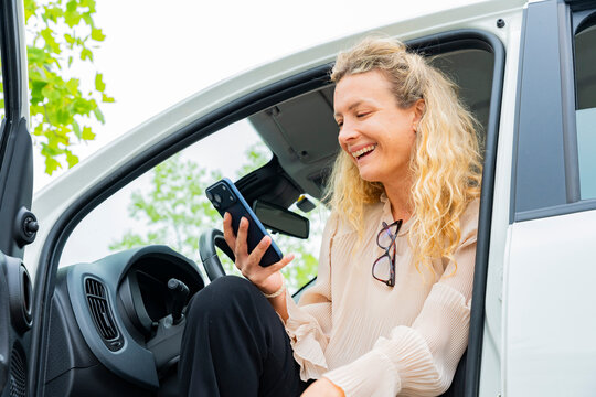 Business woman smiling in car using smartphone for call