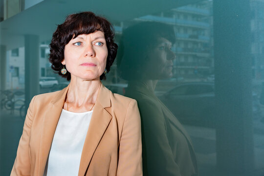 Professional businesswoman portrait by office glass wall