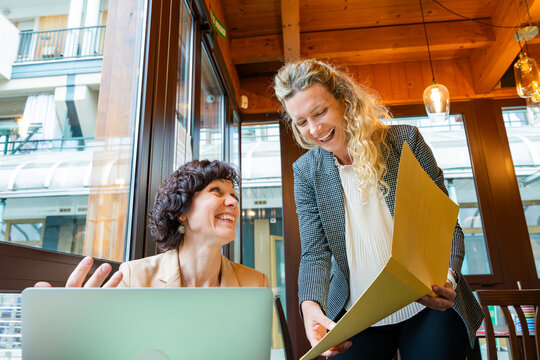 Businesswomen discussing work in a modern urban cafe
