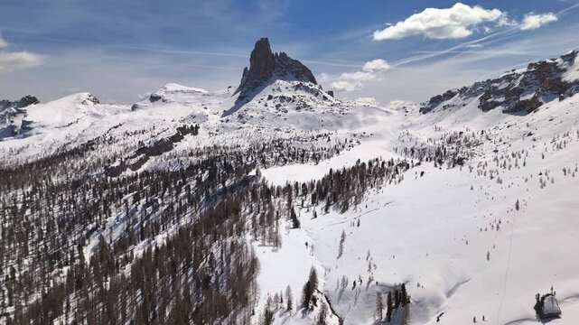 Aerial pan across snow-covered Dolomite landscape with Becco di Mezzod&Atilde;&not; spire, Cortina, Italy