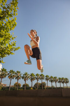 Athletic woman jumping outdoors, training with resilience