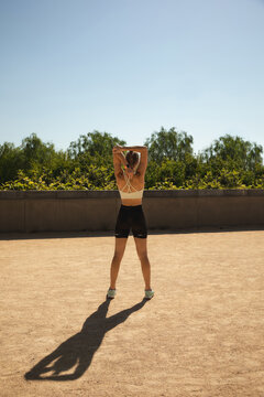 Woman stretching outdoors in morning sun, resilience training