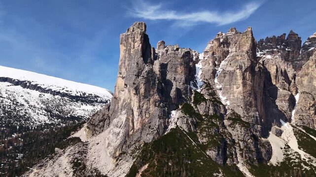 Drone orbit of Torre Trieste rock towers below Civetta wall with blue sky, Dolomites