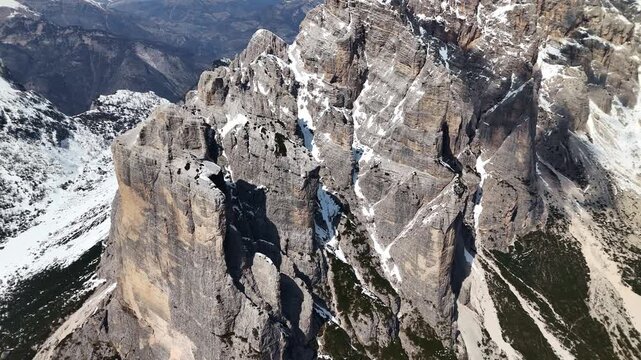 Close drone flythrough between Torre Trieste rock pillars with Civetta wall behind, Dolomites