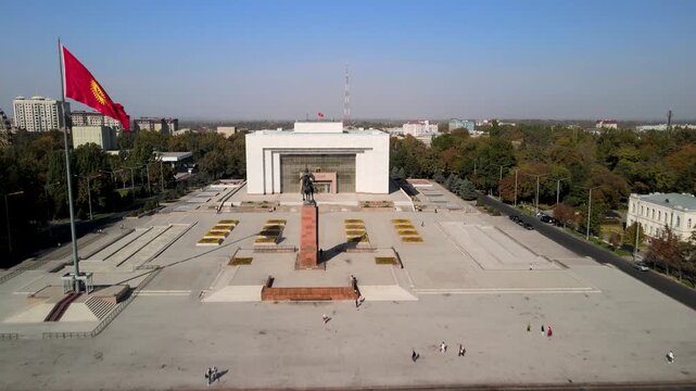 Aerial view of Ala-Too Square, the central public square of Bishkek, Kyrgyzstan. The wide open plaza, national flag, surrounding government buildings, and the urban landscape of the capital city.