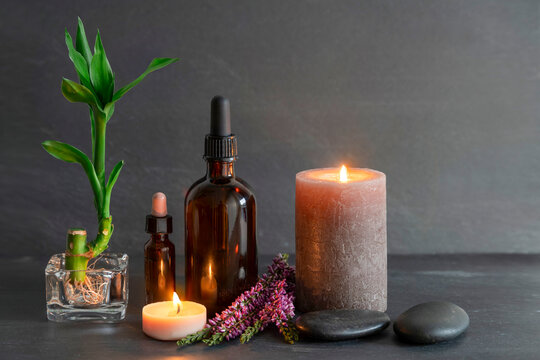 Spa still life with essential oil, candle, flower and stone